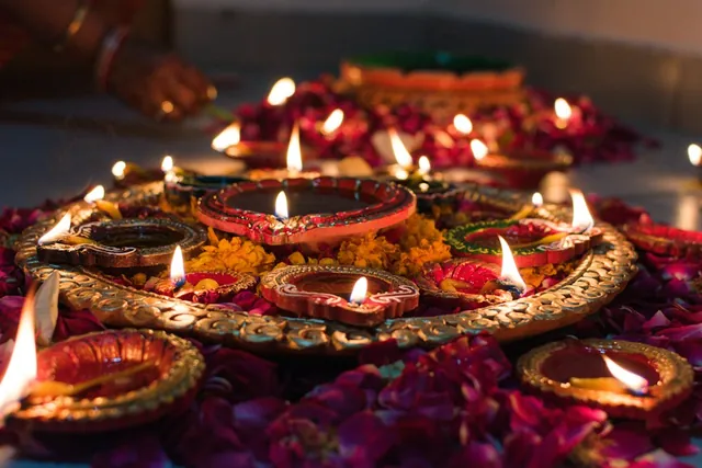 Lit diyas on a decorated tray for a festive campaign